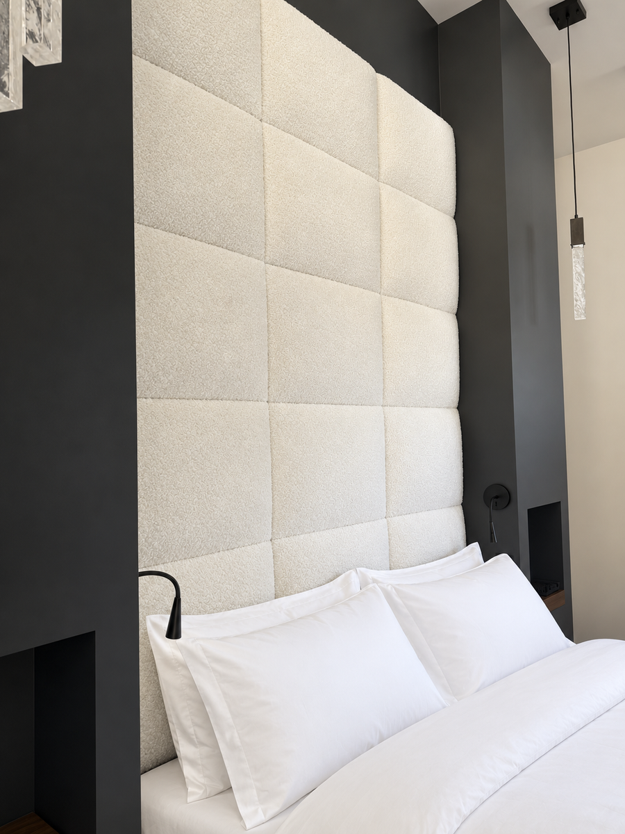 Upholstered wall panels to create a soft, pillowy texture above the bed.